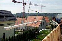 Aufzug mit Kran über's Hausdach einer 14 Meter breiten Resobox in Neftenbach.